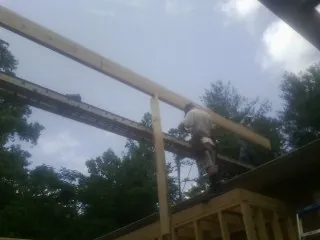 Carpenter setting a ridge beam over a new addition frame — Ice Dam Removal by Roofing Brothers in Roberta